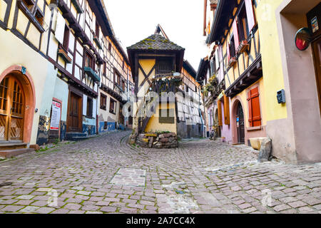 Eguisheim, Francia - 24 Marzo 2019: Street con mezzo in legno case medievali in Eguisheim villaggio lungo la famosa strada del vino in Alsazia. Foto Stock