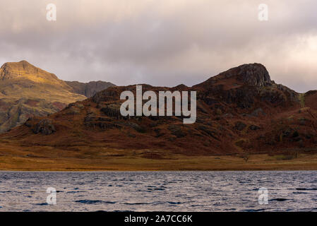 Bella e moody mattina rientrano la luce a Blea Tarn nel Lake District inglese con vedute del Langdale Pikes, e lato luccio durante l'autunno. Foto Stock