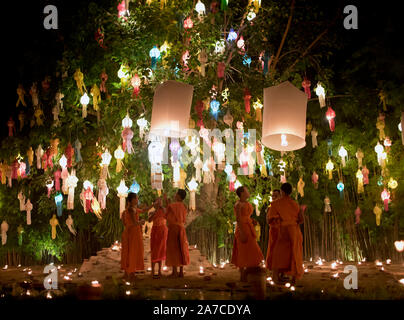 Linea di monaci con luci di candela celebrando Loy Krathong festival. Chiang Mai, Thailandia Foto Stock