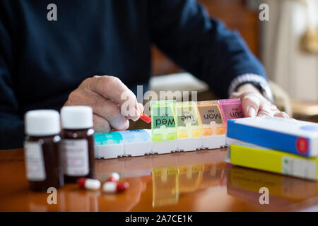 Close up uomo Senior di organizzazione di un farmaco in pillola Dispenser Foto Stock