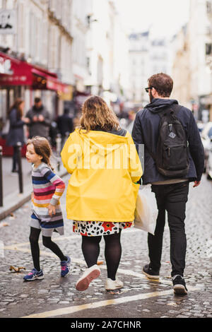 Parigi, Francia - Ottobre 06, 2019: i passanti sulla strada in un giorno nuvoloso in un impermeabile giallo Foto Stock