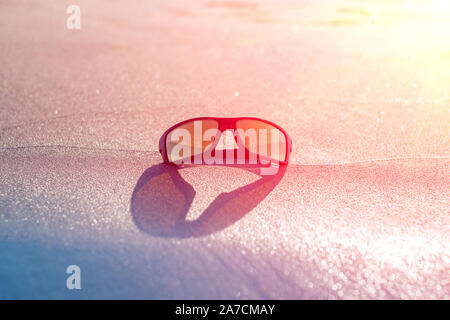 Occhiali da sole Occhiali da sole la sera su un mare spiaggia tropicale, tonificante Foto Stock