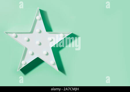Bianco Lampada al neon come stella con le luci a LED sul neo Sfondo menta. Banner. Vista dall'alto. Lay piatto. I bambini del moderno luce da notte. Foto Stock