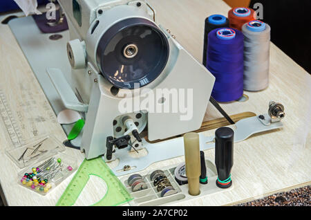 Elettrico professionale macchina per cucire situato nel laboratorio di cucito Foto Stock