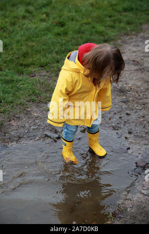Bambino in una pozza di fango Foto Stock