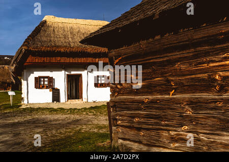 Tradizionale in legno e argilla bianche case ungherese in Szentendre Skanzen Museo del villaggio su una soleggiata giornata di primavera. Foto Stock