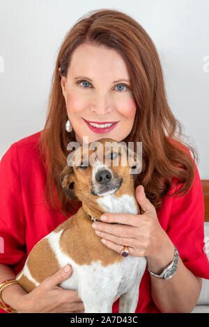 Donna sorridente in posa con il suo cane Foto Stock