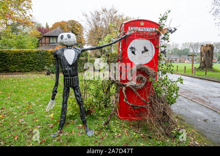 Vecchio telefono rosso scatola (telefonica) decorato per la festa di Halloween nel Surrey villaggio di Compton, Regno Unito Foto Stock