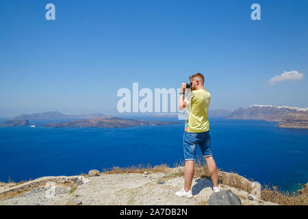 Giovane uomo fotografie il paesaggio di Santorini, Grecia Foto Stock