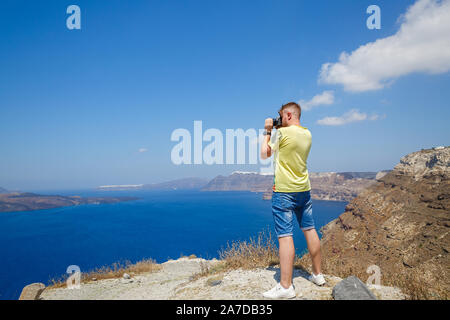 Giovane uomo fotografie il paesaggio di Santorini, Grecia Foto Stock