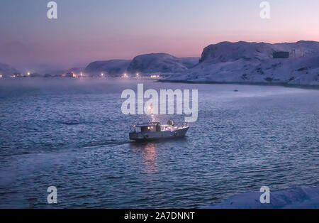 Barca da pesca vele passato montagne innevate al tramonto. Teriberka. Mare di Barents. Kolsky distretto dell'oblast di Murmansk, la Russia. Foto Stock