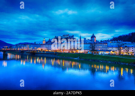 Crepuscolo serale vista del centro storico di Salisburgo con la cattedrale illuminata e Hohensalzburg Festung castle attraverso fiume Salzach in Austria Foto Stock