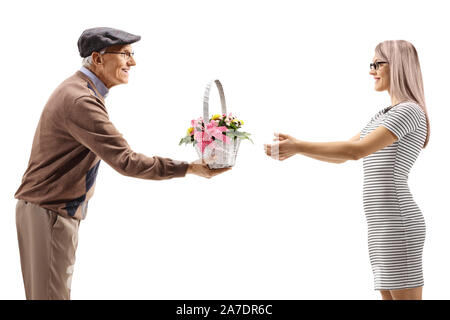 Uomo anziano dando un cesto con fiori di una giovane donna isolato su sfondo bianco Foto Stock