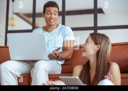Allegro giovane coppia internazionale avente una piacevole conversazione Foto Stock