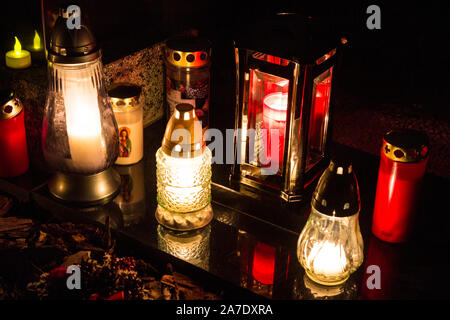 Candele accese sulla pietra tombale nella vecchia Szent Mihaly temeto (St. Michael cimitero) il giorno di Tutti i Santi, Sopron, Ungheria Foto Stock