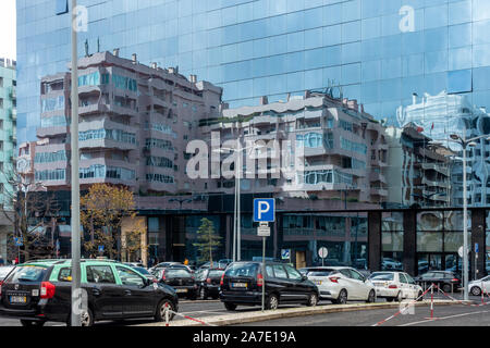 Blocchi di appartamenti riflessa in un vetro moderno edificio per uffici a Lisbona, Portogallo. Foto Stock
