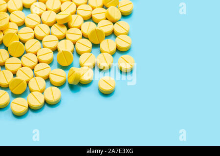 Le compresse di colore giallo di paracetamolo su sfondo blu. Foto Stock