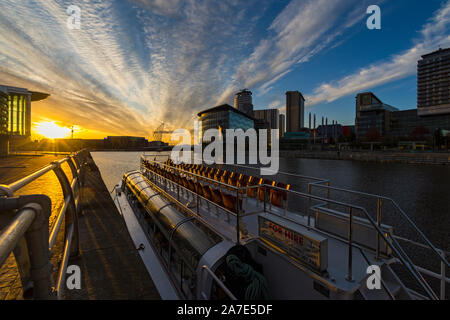 Tramonto sul MediaCityUK complesso con la principessa Katharine tour in barca in primo piano, Salford Quays, Manchester, Inghilterra, Regno Unito Foto Stock