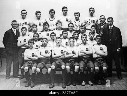 Una vendemmia tardiva o Vittoriano Inizio Edwardian fotografia in bianco e nero che mostra un gruppo di ragazzi in divise sportive, eventualmente a calcio o calcio, posa per la fotocamera con i loro manager o pullman. In Inghilterra. Foto Stock