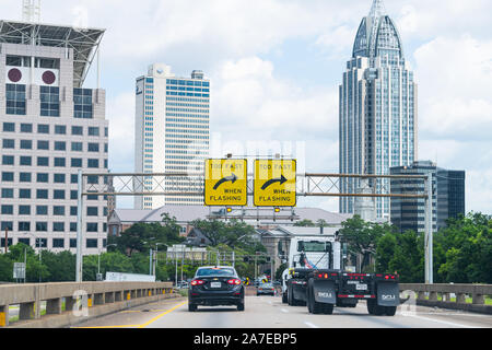 Mobile, Stati Uniti d'America - 24 Aprile 2018: Alabama centro città moderna edifici cityscape e l'autostrada Interstate 10 il traffico stradale con segno per girare Foto Stock