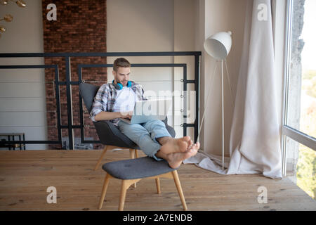 Bel giovane imprenditore di successo che lavora da casa Foto Stock