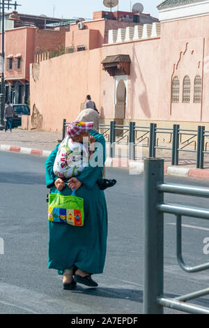 La donna araba con il bambino dietro il suo ritorno nella città di Marrakech. Il Marocco Ottobre 2019 Foto Stock