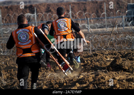 1 Novembre 2019: Gaza, Palestina. Il 01 novembre 2019. Civile palestinese squadre di difesa assistere dimostranti palestinesi come scontri scoppiati con le forze israeliane durante questo Venerdì di dimostrazioni di Abu Safiya area nel nord della Striscia di Gaza. Dal momento che la Grande Marcia di protesta di ritorno è iniziato il 30 marzo 2018, la striscia di Gaza i lavoratori della sanità hanno messo la loro vita e la loro salute sul rischi partecipando alle manifestazioni settimanali e fornendo un trattamento immediato e evacuazione di manifestanti feriti. Quattro i paramedici sono stati uccisi e più di 230 sono stati feriti dai soldati israeliani a partire dal grande marzo di Ret Foto Stock