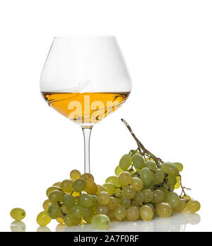 Bicchiere di vino bianco con un grappolo di uva su sfondo bianco Foto Stock