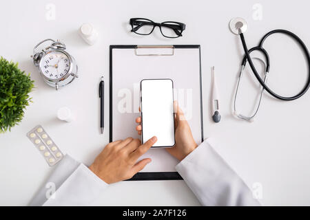 Irriconoscibile medico maschio utilizza lo smartphone con schermo vuoto al lavoro Foto Stock