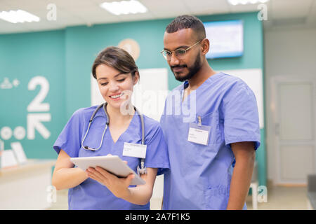 Due giovani medici di successo in uniforme guardando attraverso online nuovi medici Foto Stock