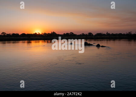 Romantico tramonto sul fiume Okavango, Caprivi Strip, Namibia, Africa - Bella, serena, panorama solitario Foto Stock