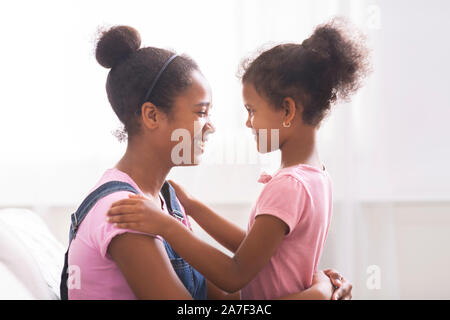 Felice ragazze africane abbracciando e guardando ogni altro Foto Stock