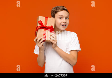 Curioso teen boy controllo dono, scuotimento presente box Foto Stock