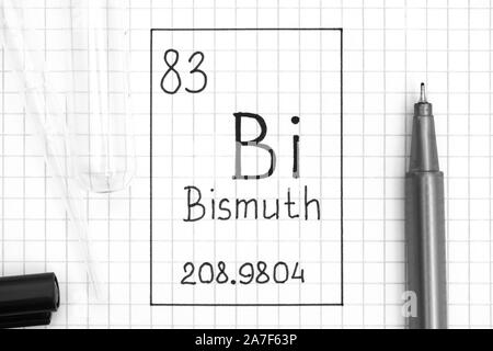 Tavola periodica degli elementi. La grafia elemento chimico Bi Bismuto con la penna nera, tubo di prova e la pipetta. Close-up. Foto Stock