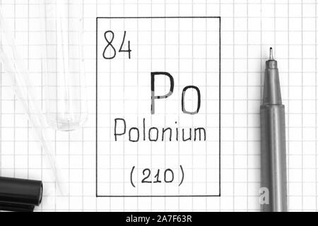 Tavola periodica degli elementi. La grafia elemento chimico del polonio Po con la penna nera, tubo di prova e la pipetta. Close-up. Foto Stock