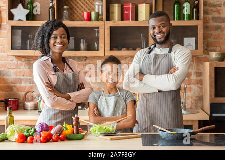 Famiglia di successo grembiuli in posa su sfondo di cucina Foto Stock