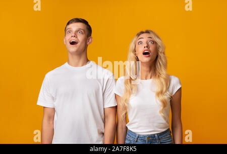 Scioccato coppia giovane guardando verso l'alto con stupore Foto Stock