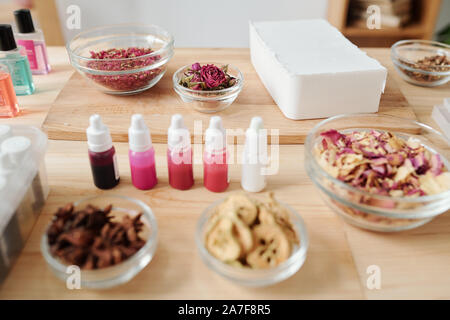 Barra del disco massa di sapone, spezie e fiori secchi, piccoli flaconi con colori Foto Stock