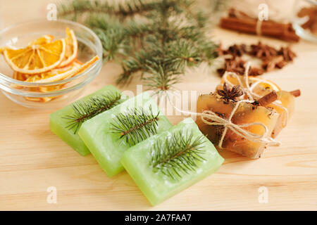 Fresche fatte a mano le barre di sapone profumato dalle conifere e spezie aromatiche sul tavolo Foto Stock