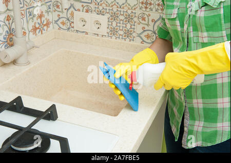 Guanto lavaggi casalinga armadi, lavello e fornello in cucina Foto Stock