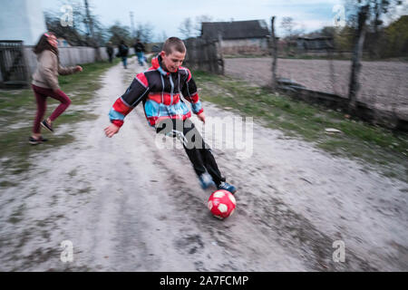 Due bambini di giocare a calcio all'interno della centrale di Cernobil Zona di esclusione. L'Ucraina Foto Stock