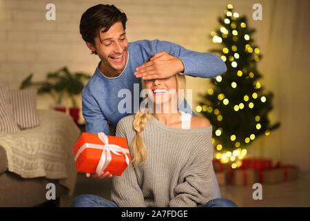 Coppia giovane lo scambio di doni alla vigilia di Natale Foto Stock