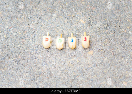 Dreidels per Hanukkah. Dreidels in legno per giocare a un gioco durante la festa ebraica di Chanukah.Le lettere sulla dreidel sono le prime lettere espressione ebraica che significa un grande miracolo accaduto qui. Foto Stock