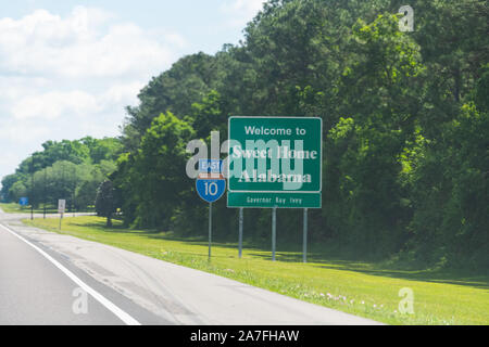 Autostrada strada in Alabama e Mississippi confine di stato segno di benvenuto e testo su strada sulla Interstate i10 in Grand Bay, AL Foto Stock