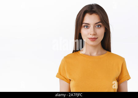 Close-up determinato seducente moderno ed elegante brunette donna in giallo t-shirt, sorridente e guardare avanti con fiducia, motivata espressione Foto Stock