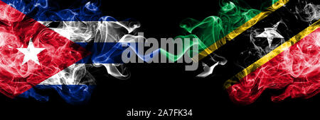 Cuba, cubana vs Saint Kitts e Nevis smoky mystic bandiere poste fianco a fianco. Spessa colorata setosa astratto di viaggio fuma banner Foto Stock