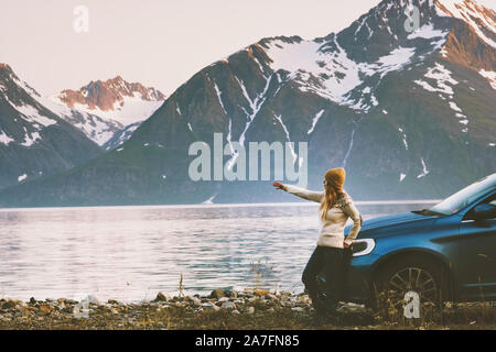 Driver di donna che viaggiano in auto a noleggio durante un viaggio in Norvegia avventura concetto lifestyle vacanze outdoor montagne e vista del fiordo Foto Stock