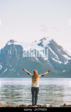 Donna felice le mani alzate godendo la Norvegia vista montagne Viaggi Vacanze avventura di uno stile di vita sano concetto di libertà Lyngen Alpi e paesaggio del fiordo Foto Stock