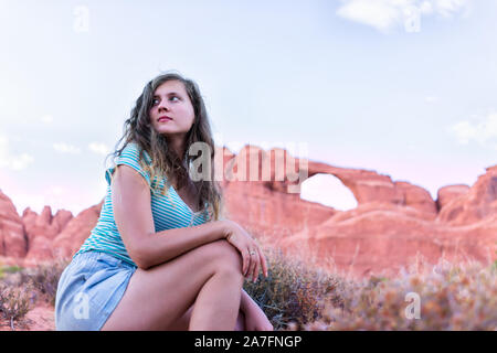 Canyon Arches National Park con Skyline Arch in background e donna giovane ragazza angolo basso cercando sul sentiero escursione in Utah Foto Stock