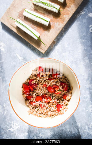 Insalata di farro fatta con scritto cotte ,pomodori ciliegia, erba cipollina e formaggio feta formaggio greco. Foto Stock